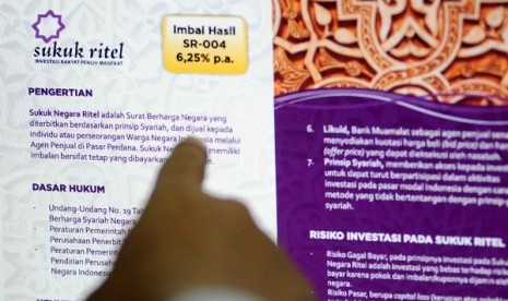 A member staff points digital brochure offering retail sukuk SR 004 in an Islamic bank in Jakarta. (illustration)  