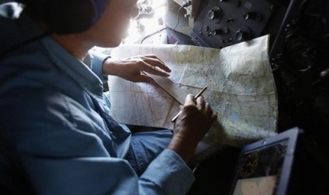 A military officer works on a map onboard a Vietnam Air Force AN-26 aircraft during a mission to find the missing Malaysia Airlines flight MH370, off Con Dao island, March 13, 2014.