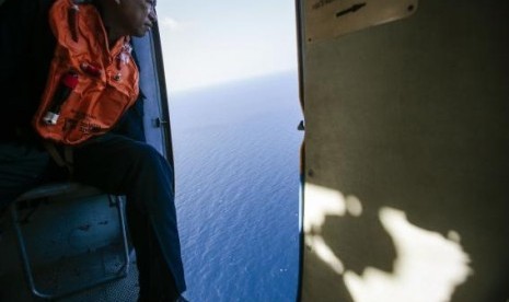 A military personnel looks out of a helicopter during a search and rescue mission off Vietnam's Tho Chu island March 10, 2014.