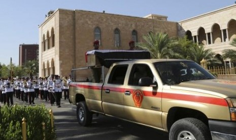 A military vehicle transports the coffin of Major General Negm Abdullah Ali, commander of the army's sixth division, during a funeral ceremony at the defence ministry in Baghdad July 7, 2014.