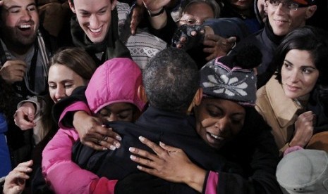 A mother and daughter hug U.S. President Barack Obama at the same time during a campaign rally in Bristow, Virginia, November 3, 2012.   