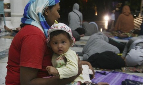 A mother holds her child as she seeks shelter in Baiturrahman Mosque after an earthquake hit Banda Aceh, in Indonesia's Aceh province, April 12, 2012.