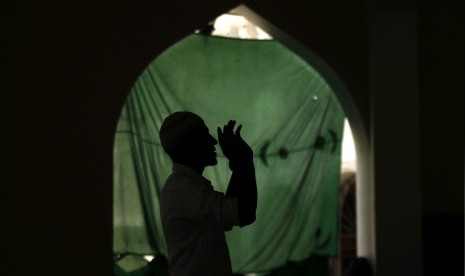 A Muslim man is silhouetted as he prays at a mosque during the month-long fasting on Ramadan in Colombo Download :