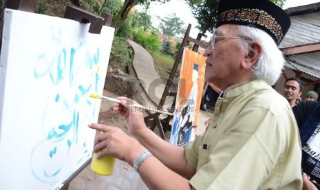  A Mustofa Bisri (Gus Mus) melukis kaligrafi pada pembukaan pameran lukisan dan puisi 'Lima Rukun' di Studio Jeihan, Bandung, Sabtu (28/9). (Republika/Edi Yusuf)