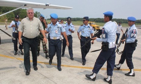 A number of Air Force officers guard a pilot of Cessna 208, Michael A Boyd (left) in Sepinggan, Balikpapan, on Sunday, after being caught entering Indonesian airspace without permit.   