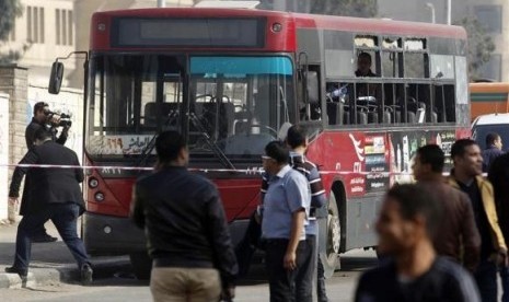 A of the media films a damaged bus after a bomb blast near the Al-Azhar University campus in Cairo's Nasr City district December 26, 2013.