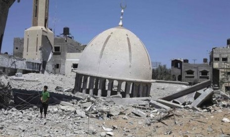 A Palestinian boy stands next to the remains of a mosque in Khuzaa town, which witnesses said was heavily hit by Israeli shelling and air strikes during Israeli offensive, in Gaza Strip August 6, 2014.