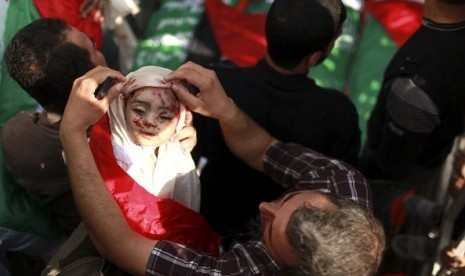 A Palestinian man adjusts the shroud covering the body of a child belonging to the al-Dalo family during his funeral in Gaza City November 19, 2012. Nine members of the al-Dalo family, including four children, were killed in an Israeli strike on their house on Sunday, Palestinian medics said.   