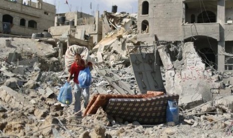 A Palestinian man carries his belongings from his destroyed house in Beit Hanoun town, which witnesses said was heavily hit by Israeli shelling and air strikes during Israeli offensive, in the northern Gaza Strip July 26, 2014. 