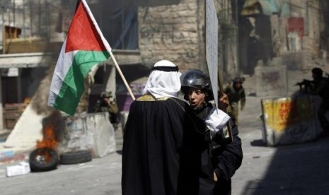 A Palestinian man holding a Palestinian national flag argues with an Israeli policewoman, during a protest against the Israeli offensive in Gaza, in the West Bank city of Hebron August 22, 2014.