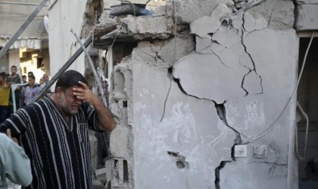 A Palestinian man reacts as he stands next to the wreckage of a house, which witnesses said was destroyed in an Israeli air strike that killed at least nine members from the al-Ghol family, in Rafah, August 3, 2014.