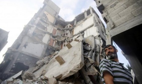 A Palestinian man stands near the remains of a charitable organization building, which witnesses said was hit by an Israeli air strike, in Khan Younis in the southern Gaza Strip August 25, 2014.