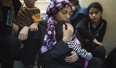 A Palestinian mother comforts her child in a hospital a few hundred meters from where medics said Israeli shelling hit a UN-run school sheltering Palestinian refugees, in Beit Hanoun the northern Gaza Strip July 24, 2014.