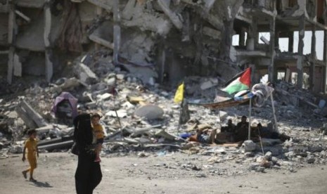 A Palestinian returns to her house during a 72-hour truce in Beit Lahiya town, which witnesses said was heavily hit by Israeli shelling and air strikes during the Israeli offensive, August 11, 2014. 