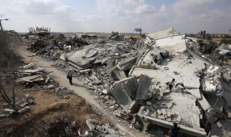 A Palestinian woman walks past the ruins of houses which witnesses said were destroyed during the Israeli offensive in Johr El-Deek village near the central Gaza Strip August 17, 2014.