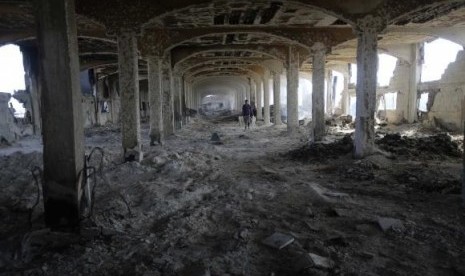 A Palestinian worker walks inside al-Awdah food factory, which witnesses said was shelled and torched by the Israeli army during the offensive, in Deirl al-Balah in the central Gaza Strip August 14, 2014.