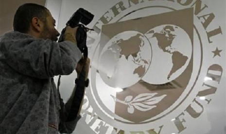 A photographer takes pictures through a glass carrying the International Monetary Fund (IMF) logo. (file photo)