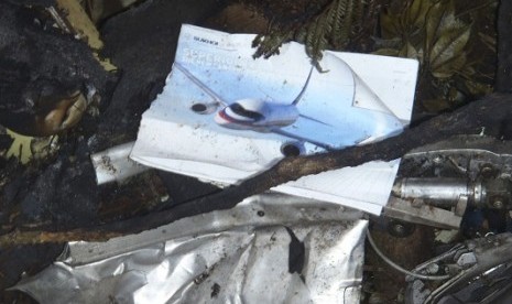 A picture of a Russian Sukhoi aircraft is seen between wreckage of this aircraft on the slope of Mount Salak, near Bogor.