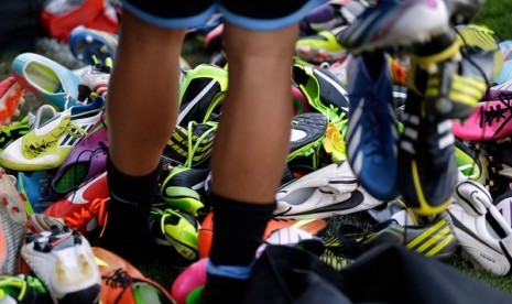 A player looks for his soccer shoes among a pile. (illustration) 