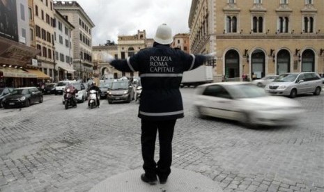 A policeman gestures as he directs traffic in downtown Rome January 24, 2014. 