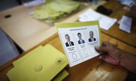 A polling station official holds a ballot paper in Turkey's first direct presidential elections at a polling station in Ankara August 10, 2014.