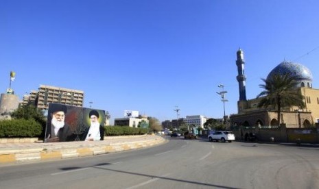 A poster depicting images of Shi'ite Iran's Supreme Leader Ayatollah Ali Khamenei is displayed at al-Firdous Square in Baghdad February 12, 2014.