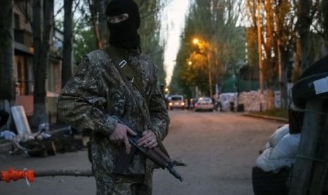 A pro-Russian armed man stands guard at a barricade near the state security service building in Slaviansk, April 25, 2014.