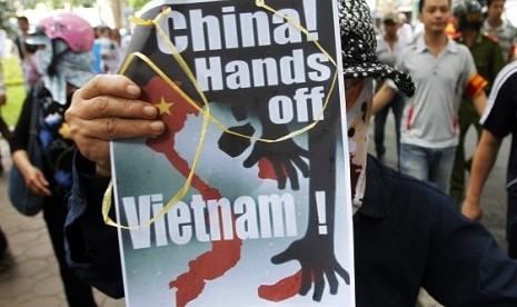 A protester holds an anti-China placard as she marches during a demonstration along a street in Hanoi July 8, 2012. Some hundred Vietnamese demonstrated in Hanoi on Sunday against China's moves to strengthen its claim on disputed islands in the South China