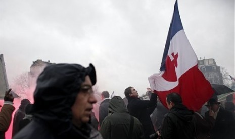 A protestor holds a French flag during a demonstration to criticize President Francois Hollande, in Paris, Sunday, Jan. 26, 2014. 