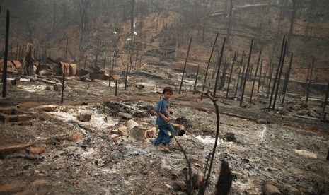 A refugee boy walks through the ruins of the Ban Mae Surin refugee camp near Mae Hong Son March 24, 2013. 