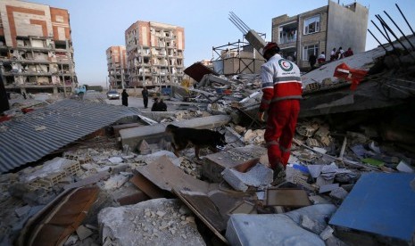 A rescue worker searches debris for survivors with his sniffing dog after an earthquake at the city of Sarpol-e-Zahab in western Iran, Monday, Nov. 13, 2017. A powerful earthquake shook the Iran-Iraq border late Sunday, killing more than two hundreds people, Iranian state media said. 