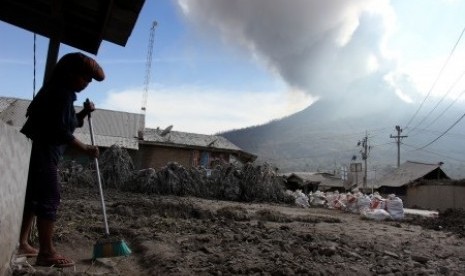 A resident cleans her house from Mount Sinabung's volcanic ash in Karo, North Sumatra, last week. (File photo)