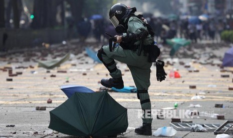 Polisi menginjak-injak payung di area kampus Hong Kong Polytechnic University. Polisi mengepung kampus dengan ratusan mahasiswa pengunjukrasa di dalamnya