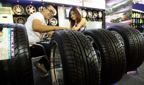 A salesperson helps a prospective buyer in a stand of PT Multistrada Arah Sarana during an exhibition in Jakarta. (illustration) 