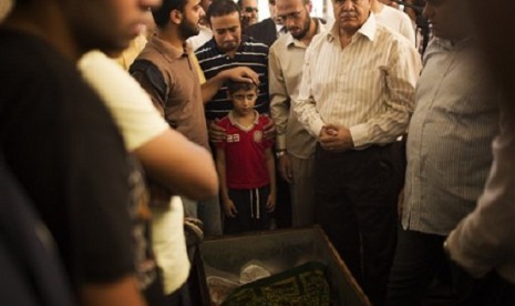 A son of Muslim Brotherhood's spiritual leader Mohammed Badie, prays while attending his burial in Cairo's Katameya district, Egypt, Sunday, Aug. 18, 2013. 