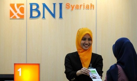 A student (left) provides mini banking services in a university in Jakarta. Mini banking program aims at providing opportunity for students to practice their skill and knowledge in banking sector.  