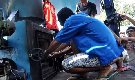 A suspect of meth smuggling puts the confiscated meth into a machine to destroy it in Jakarta on Thursday.