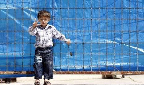 A Syrian refugee boy gestures as he stands in front of the fence at Yayladagi refugee camp in Hatay province near the Turkish-Syrian border on April 17. 