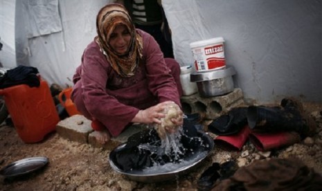 A Syrian refugee woman washes some clothes in front of her tent in a refugee camp near Azaz, north of Aleppo province, Syria. (file photo)