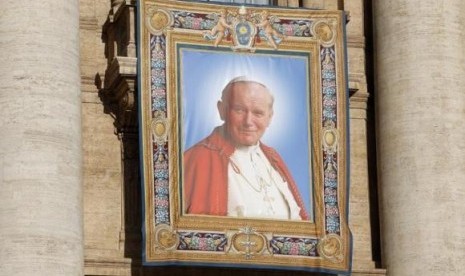 A tapestry featuring Pope John Paul II is seen in St. Peter's square at the Vatican, April 25, 2014.