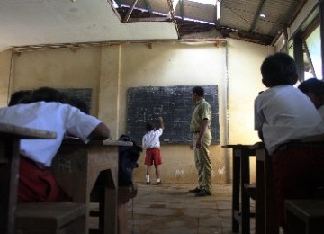 A teacher teaches in a nearly collapsed class in Malang, East Java (illustration).