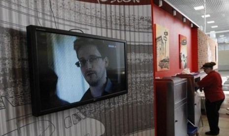 A television screens the image of former US spy agency contractor Edward Snowden during a news bulletin at a cafe at Moscow's Sheremetyevo airport June 26, 2013.