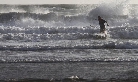 A tourist surfing in Seminyak, Bali.