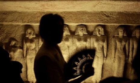 A tourist uses a hand fan, inside the tomb that belongs to Queen Meresankh III at the historical site of the Giza Pyramids, near Cairo, Egypt. (illustration)  