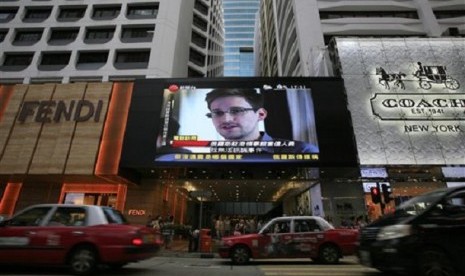 A TV screen shows a news report of Edward Snowden, a former CIA employee who leaked top-secret documents about sweeping US surveillance programs, at a shopping mall in Hong Kong Sunday, June 23, 2013. 