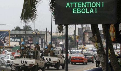 A UN convoy of soldiers passes a screen displaying a message on Ebola on a street in Abidjan August 14, 2014.