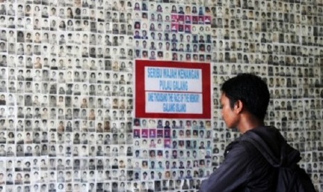 A visitor watch closely the pictures of ex-Vietnamese refugees at a museum in Galang Island, Batam.   