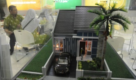 A visitor watches closely a miniature of housing in an exhibition in Jakarta. A (file photo)