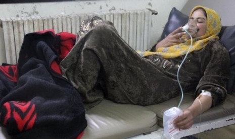 A woman, affected by what activists say was a gas attack, breathes through an oxygen mask inside a field hospital in Kfar Zeita village in the central province of Hama April 12, 2014.