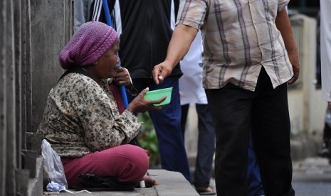 A woman begs in a pedestrian lane. (illustration)